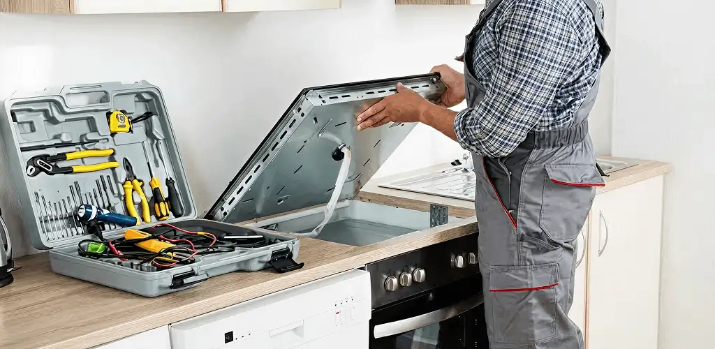 Handyman repairing a cooktop and checking wiring connections in Irvine, CA