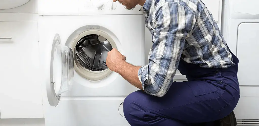 Handyman inspecting a dryer drum and internal parts for repair in Irvine, CA