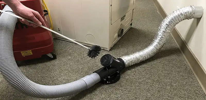 Dryer vent cleaning service removing lint from a dryer duct connection in Irvine, CA