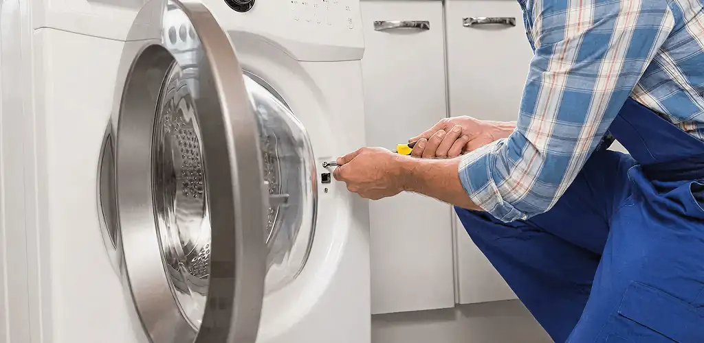 Handyman repairing a clothes dryer and checking electrical connections in Irvine, CA