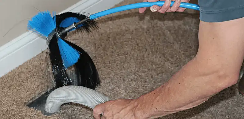 Dryer vent cleaning technician brushing lint from a vent line in Irvine, CA