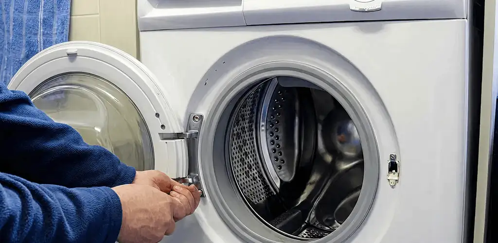 Washing machine repair handyman checking a front-load washer door and latch in Irvine, CA