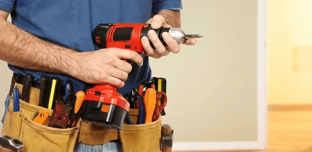 Handyman holding a power drill for home repairs and installations in Irvine, CA