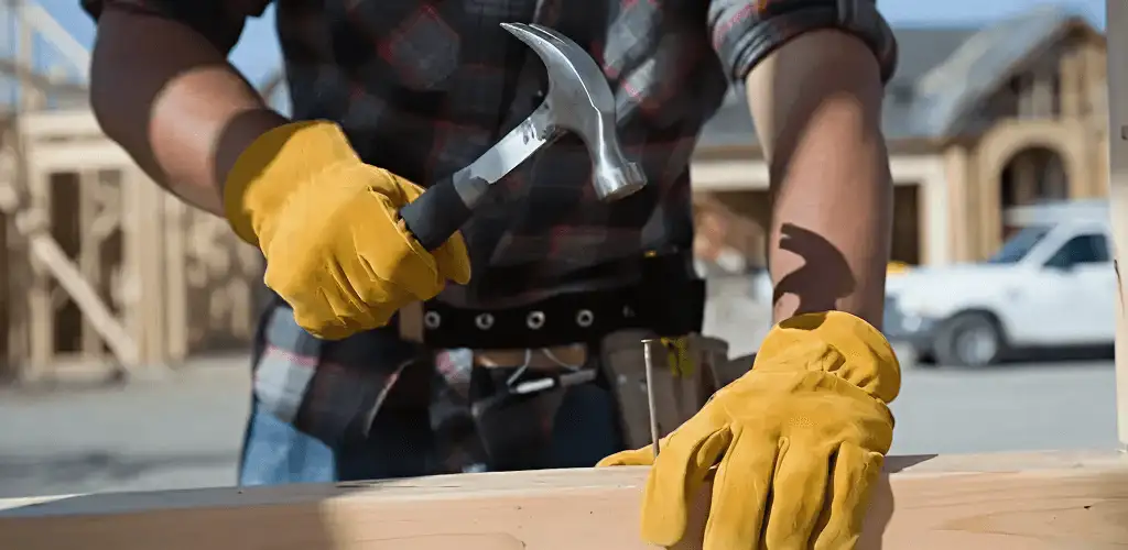 Handyman fixing wood trim with a hammer for home repairs in Irvine, CA