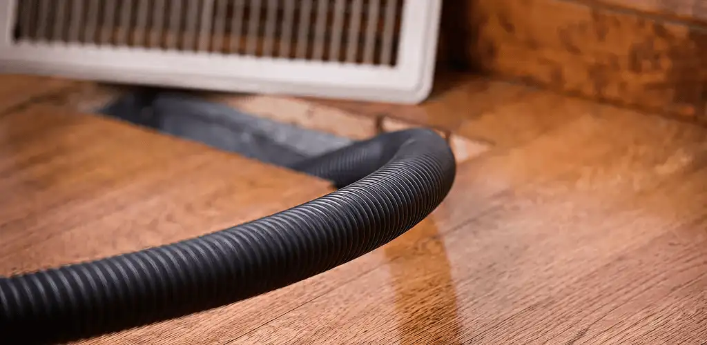 Air duct cleaning hose inserted into a floor vent for ductwork cleaning in Irvine, CA