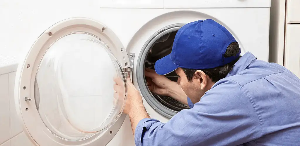Washing machine repair handyman inspecting a front-load washer drum in Irvine, CA